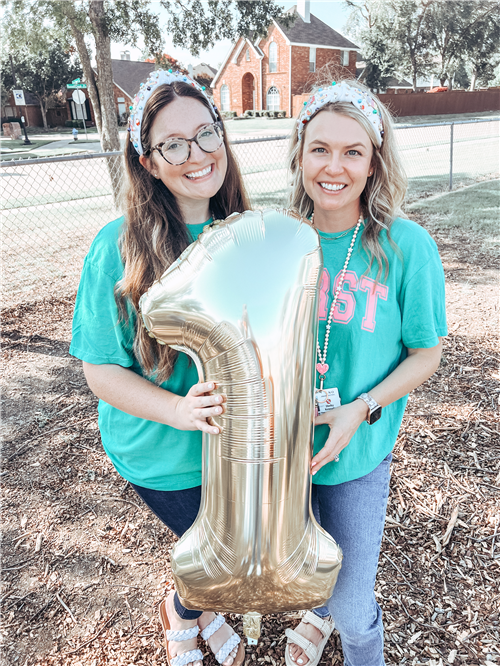 The Skaggs 1st grade smiling in the playground, holding a giant gold ballon 1